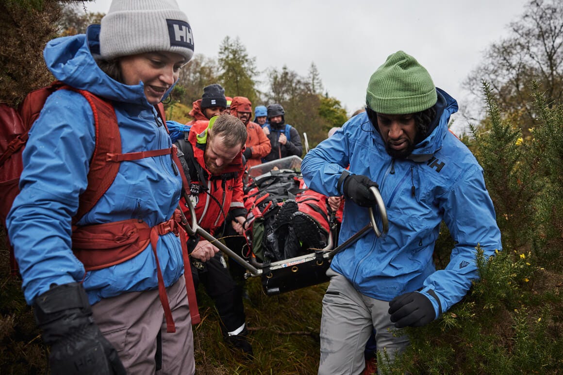 People carrying a stretcher in the outdoors