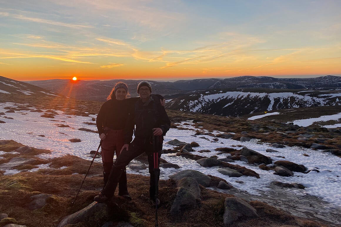 Two people standing on top of a mountain