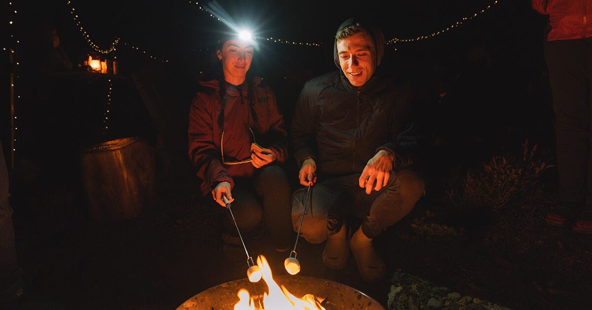 Two people by a fireplace in the mountains