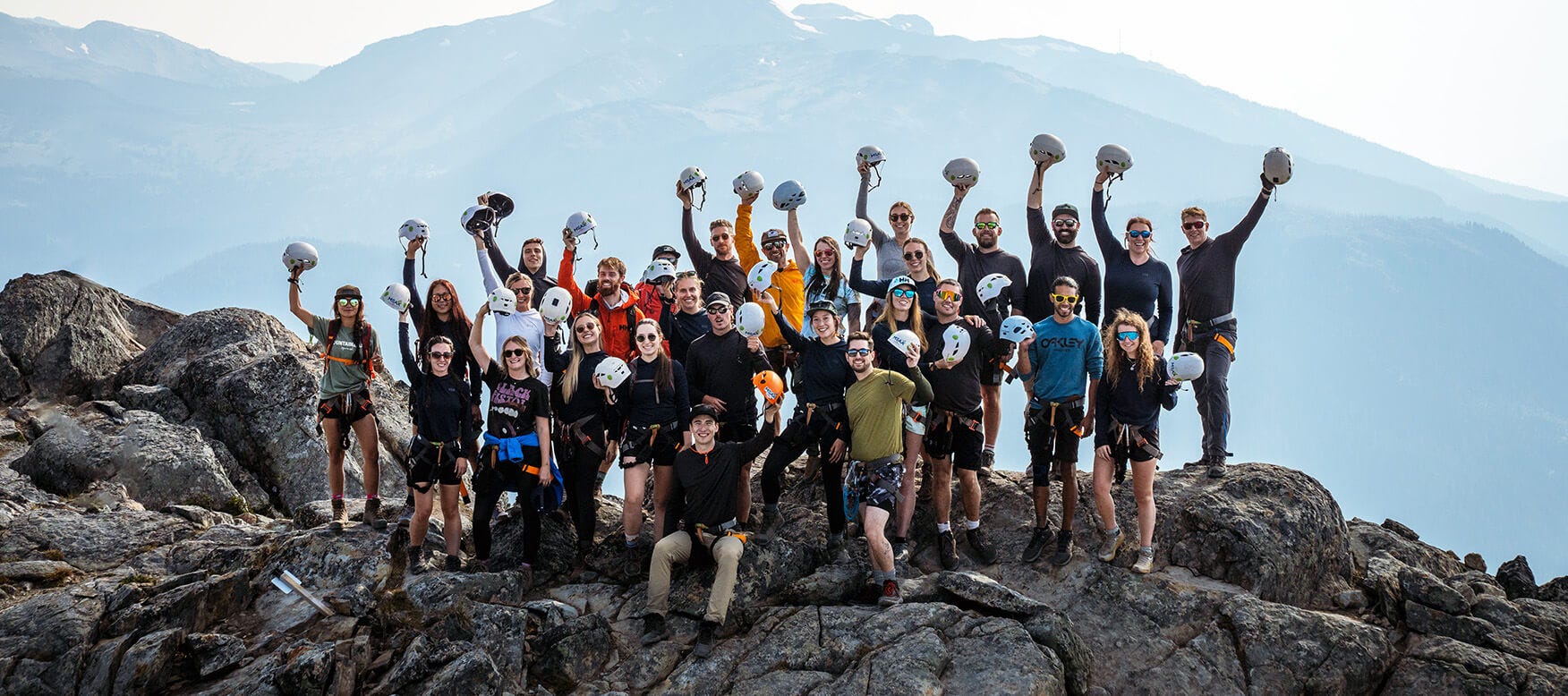 group of people cheering at the top of a mountain