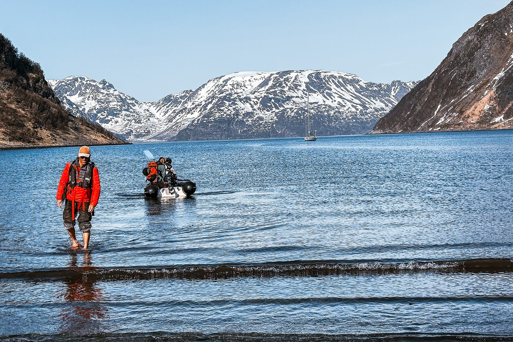 Skier wading towards shore on a beach in Finnmark