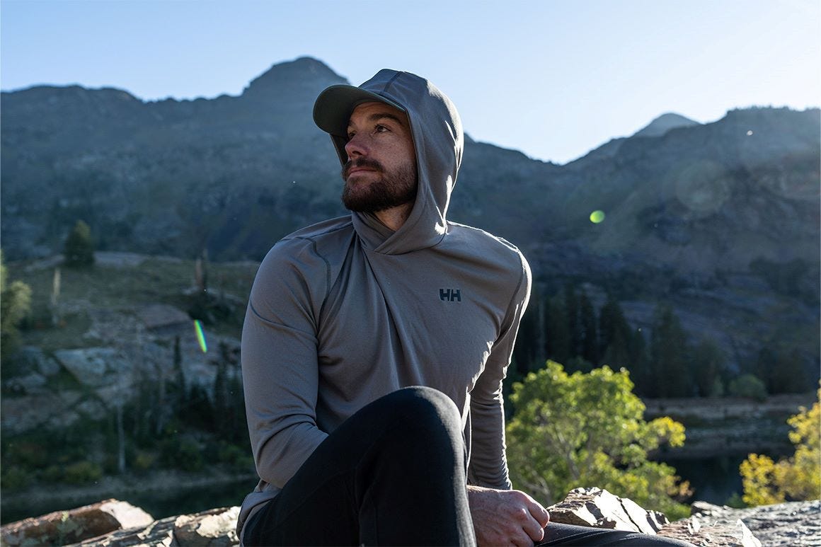 man wearing a hooded base layer on a hike