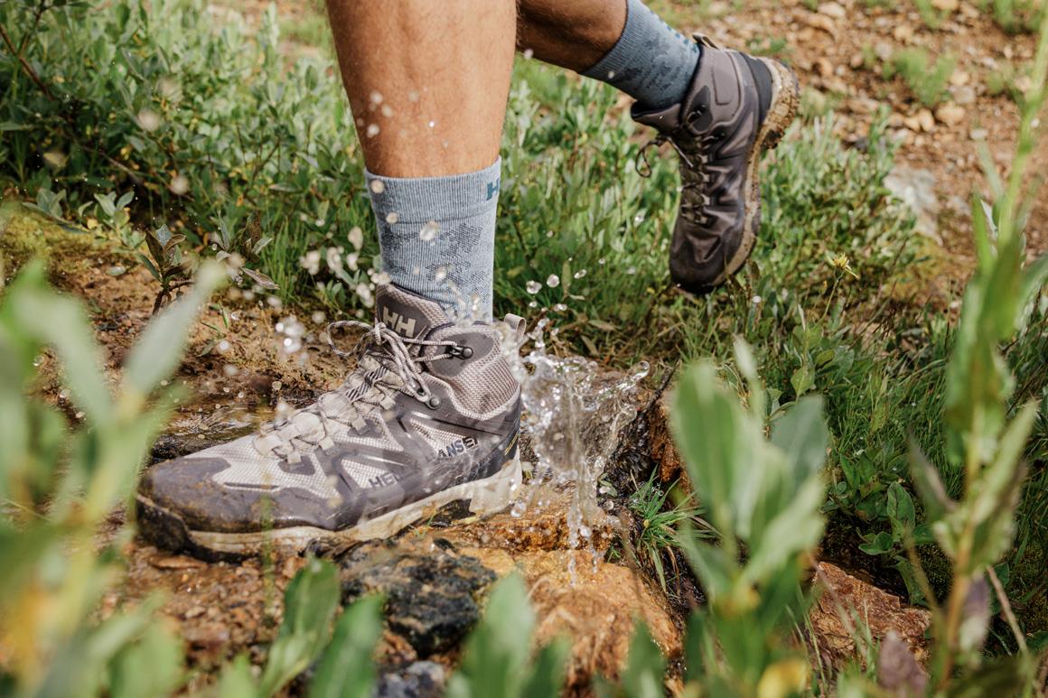 Closeup of the Cascade Helly Tech® Waterproof mid-cut hiking boots crossing a stream.